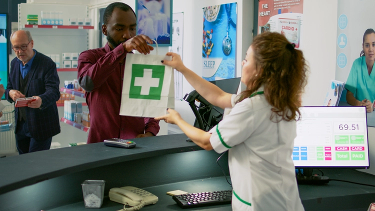 Pharmacist handing medication to a patient